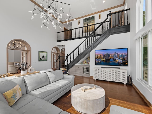 living room featuring hardwood / wood-style flooring, a towering ceiling, and a chandelier