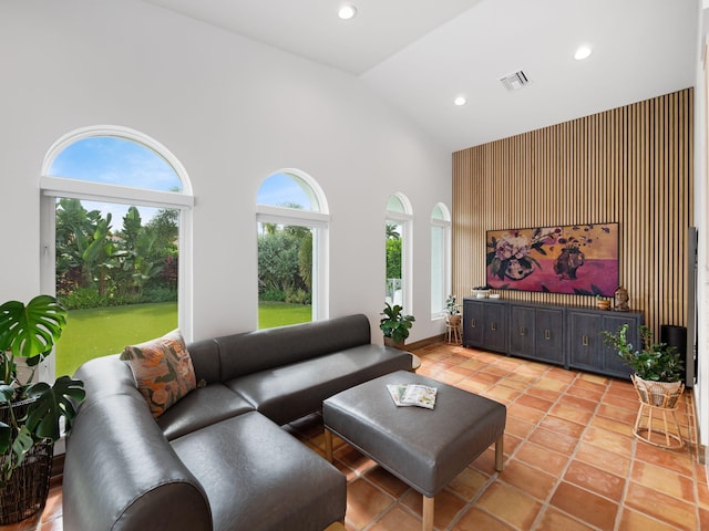 tiled living room featuring high vaulted ceiling