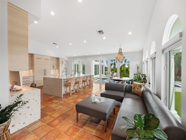 living room with light tile patterned floors, sink, and french doors