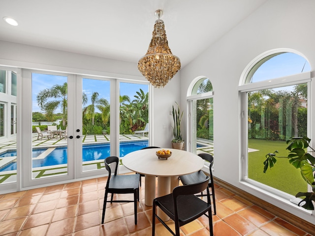 tiled dining area featuring a wealth of natural light, an inviting chandelier, and french doors