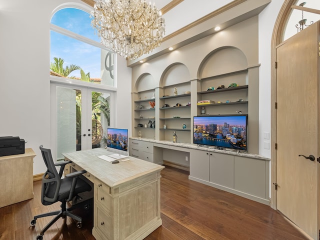 office area with built in features, dark hardwood / wood-style floors, a chandelier, built in desk, and french doors