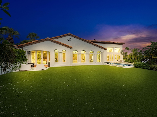 back of property with a patio and a lawn