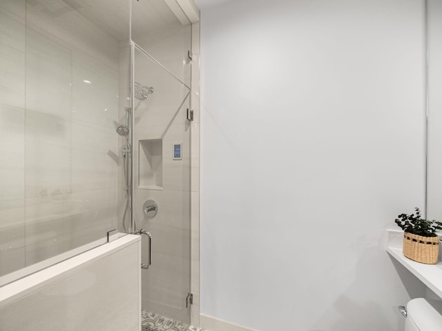 bathroom with walk in shower and toilet