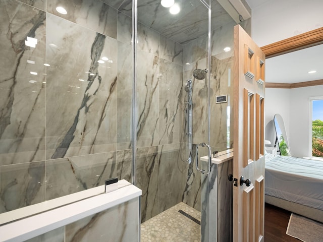 bathroom featuring an enclosed shower, wood-type flooring, and ornamental molding