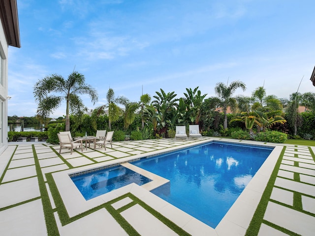 view of swimming pool featuring a patio and an in ground hot tub