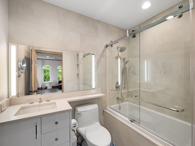 full bathroom featuring toilet, vanity, and enclosed tub / shower combo