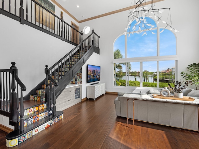 living room with dark wood-type flooring, a high ceiling, and ornamental molding