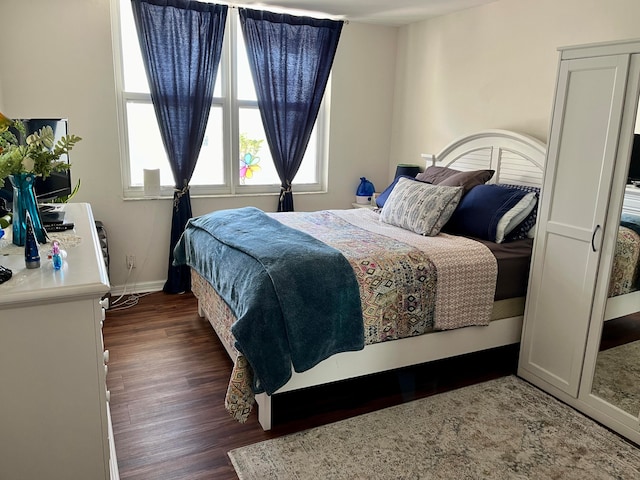 bedroom with dark hardwood / wood-style floors