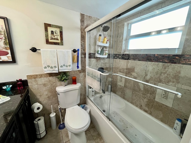 full bathroom featuring toilet, tile patterned flooring, vanity, tile walls, and shower / bath combination with glass door