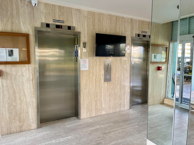 interior space featuring elevator and ornamental molding