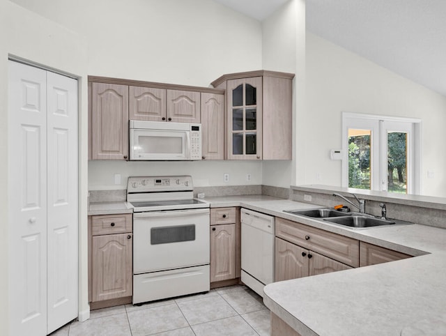 kitchen featuring light brown cabinetry, light tile patterned floors, vaulted ceiling, white appliances, and sink