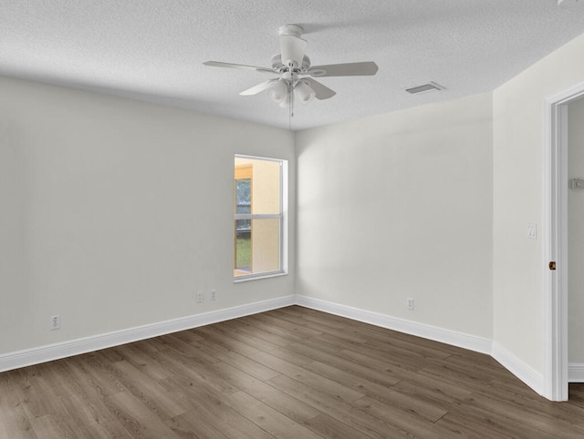 unfurnished room featuring a textured ceiling, dark wood-type flooring, and ceiling fan