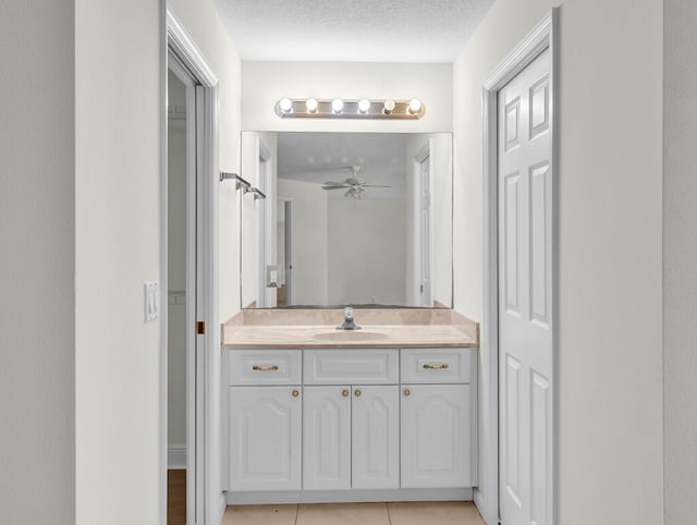 bathroom with tile patterned floors, ceiling fan, a textured ceiling, and vanity