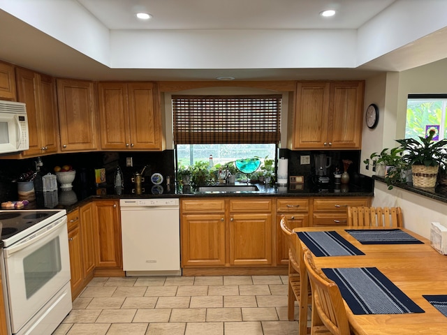 kitchen featuring decorative backsplash, sink, white appliances, and a wealth of natural light