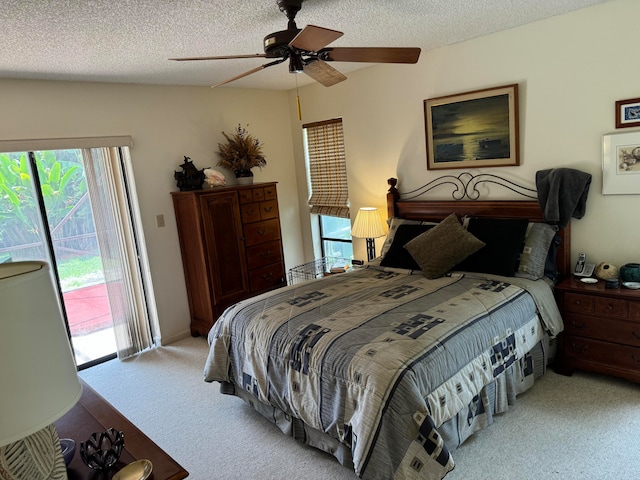 bedroom featuring ceiling fan, light colored carpet, a textured ceiling, and access to exterior