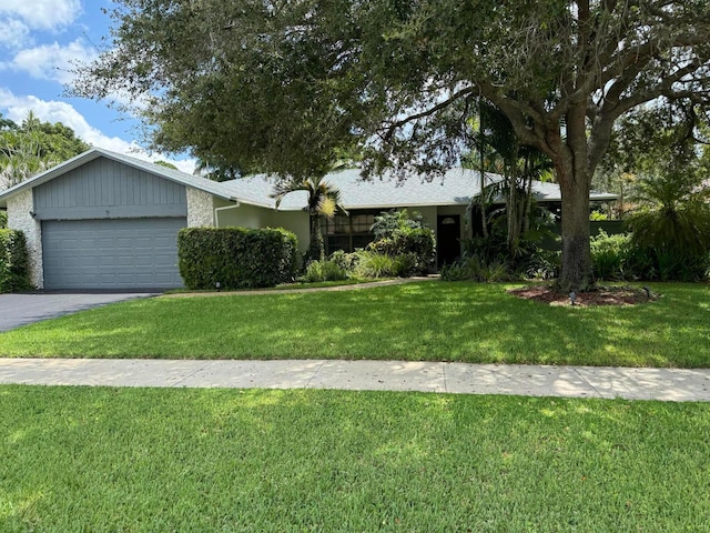 single story home featuring a garage, driveway, and a front yard