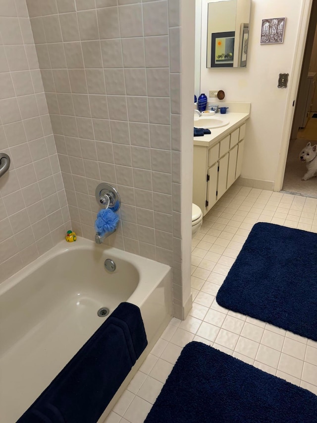 bathroom featuring tile patterned flooring, a bathtub, vanity, and toilet