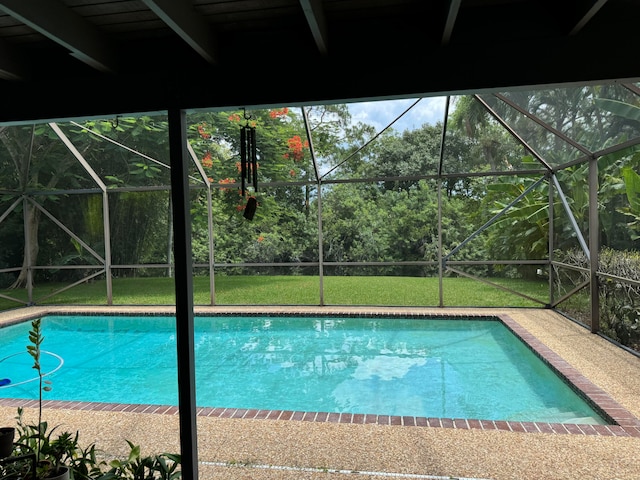 view of pool with a patio, a yard, and a lanai