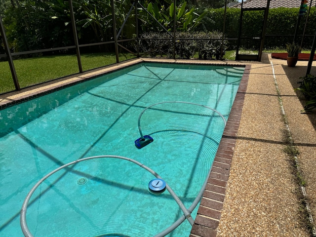 view of pool with glass enclosure