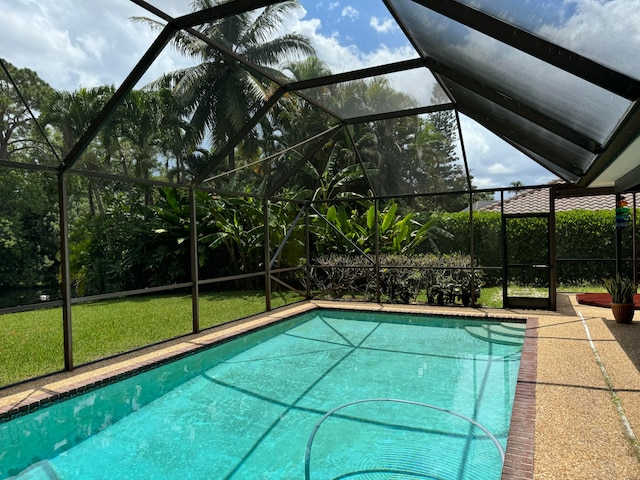 view of swimming pool with a lanai and a lawn