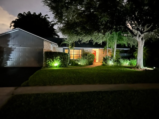 yard at dusk featuring a garage