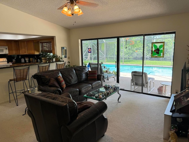 carpeted living room with vaulted ceiling, a textured ceiling, and ceiling fan