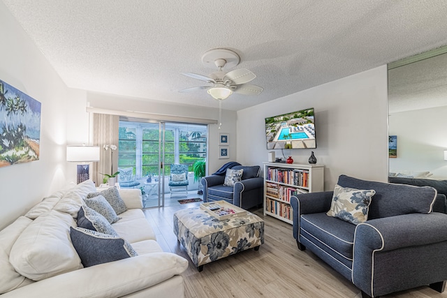 living room with a textured ceiling, light hardwood / wood-style flooring, and ceiling fan