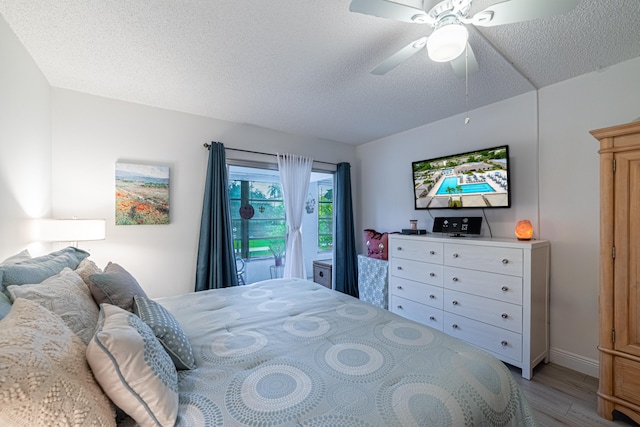 bedroom with light wood-type flooring, a textured ceiling, and ceiling fan