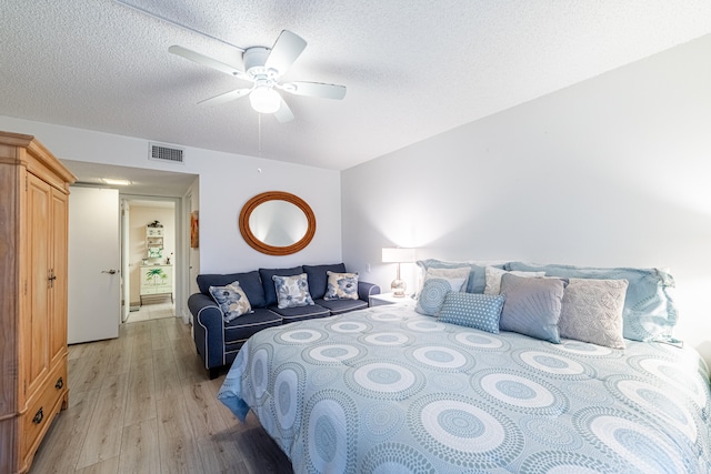 bedroom featuring a textured ceiling, ceiling fan, and light hardwood / wood-style floors