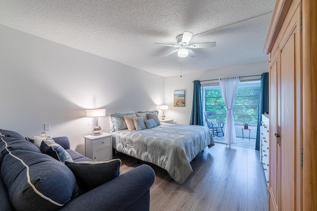 bedroom featuring ceiling fan, access to exterior, a textured ceiling, and light hardwood / wood-style flooring