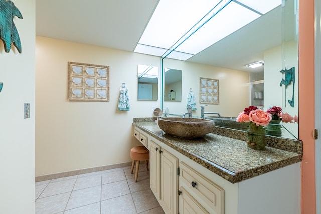 bathroom with a shower with shower door, tile patterned flooring, and vanity