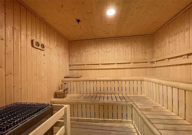 view of sauna with wood ceiling, wood-type flooring, and wooden walls