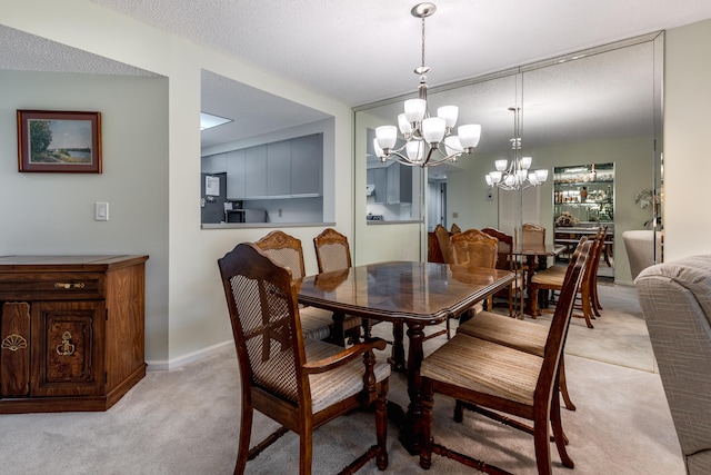 dining area with light carpet, a textured ceiling, and a chandelier