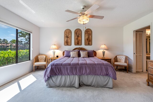 carpeted bedroom featuring ceiling fan and a textured ceiling