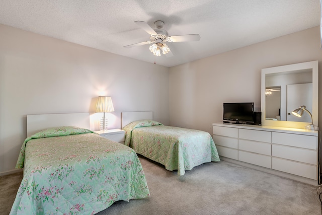 bedroom featuring a textured ceiling, ceiling fan, and light colored carpet