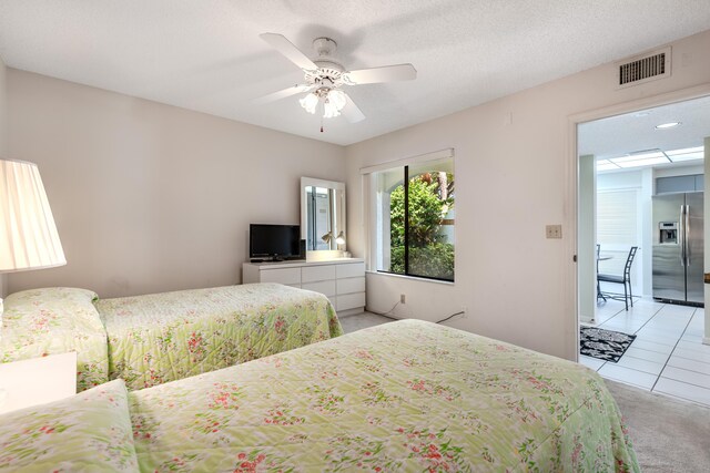 tiled bedroom with a textured ceiling, ceiling fan, and stainless steel fridge with ice dispenser