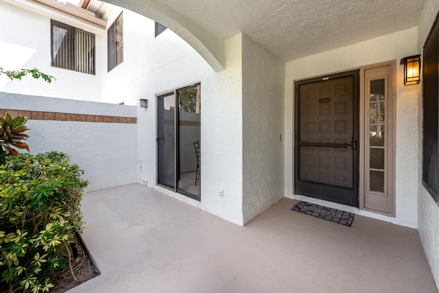 view of exterior entry with stucco siding