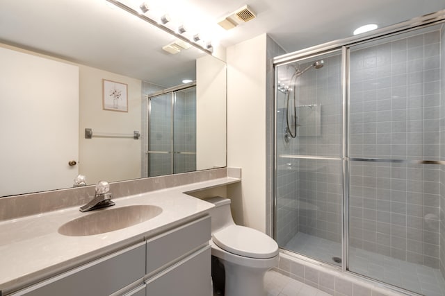 bathroom with tile patterned floors, vanity, walk in shower, and toilet