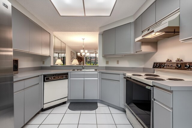 kitchen featuring custom exhaust hood, appliances with stainless steel finishes, light tile patterned floors, sink, and a notable chandelier