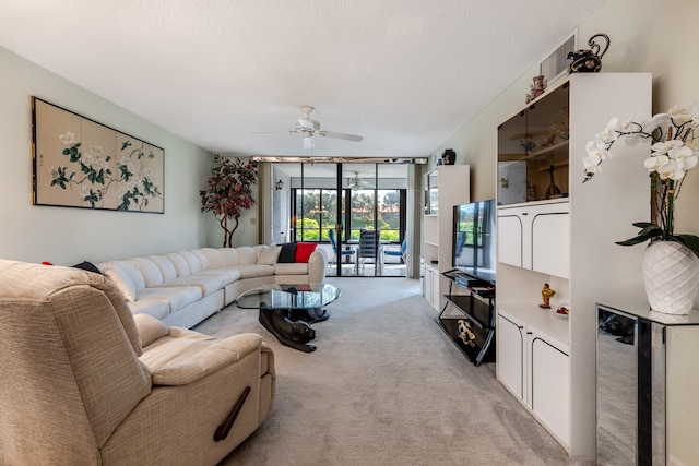 carpeted living room with ceiling fan, a textured ceiling, and a wall of windows