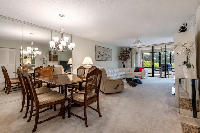 carpeted dining room featuring a textured ceiling and ceiling fan with notable chandelier