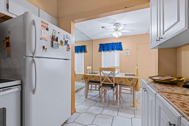 kitchen with white cabinetry, white refrigerator, ceiling fan, and light tile patterned floors