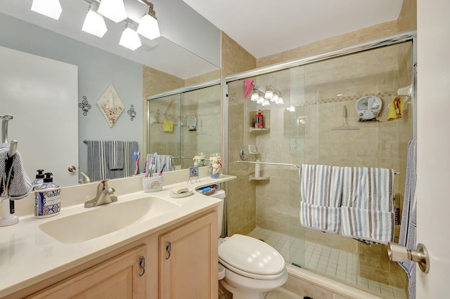 bathroom with tile patterned flooring, vanity, toilet, and a shower with shower door