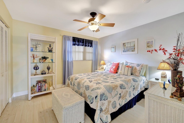 bedroom featuring ceiling fan, light wood-type flooring, and a closet