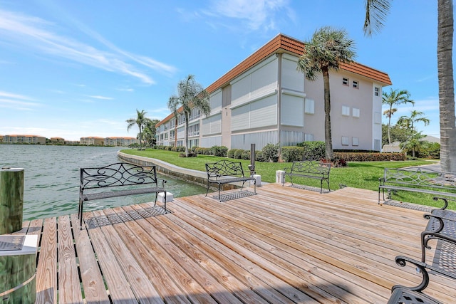 view of dock with a yard and a deck with water view