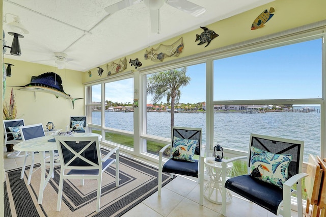 sunroom / solarium featuring a water view and ceiling fan