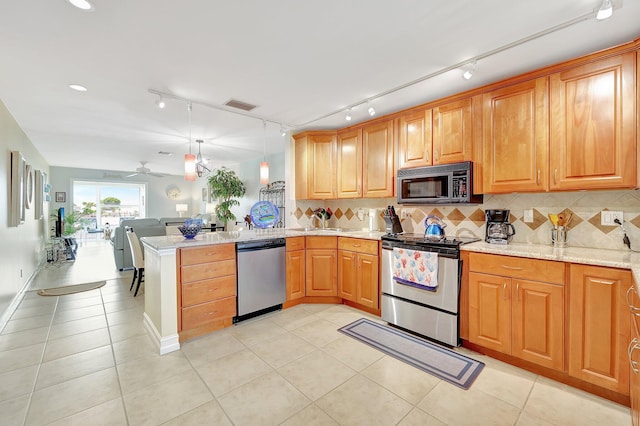 kitchen featuring backsplash, kitchen peninsula, ceiling fan, and stainless steel appliances