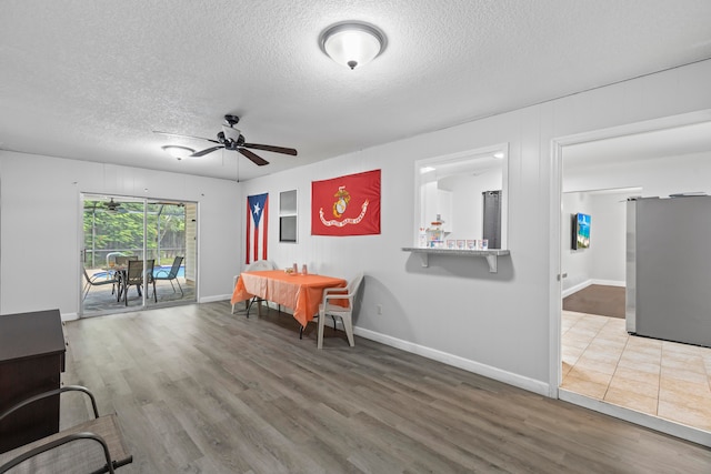 dining area with hardwood / wood-style floors, a textured ceiling, and ceiling fan