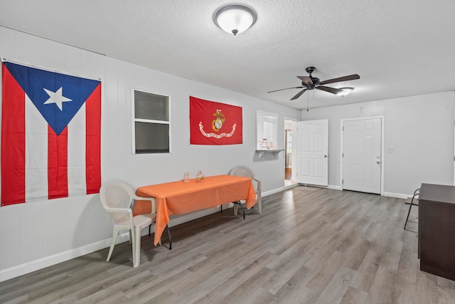 dining area with a textured ceiling, hardwood / wood-style flooring, and ceiling fan