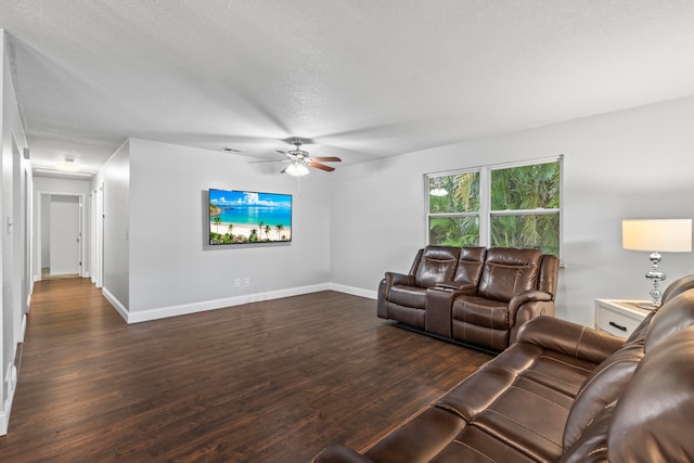 living room with ceiling fan, dark wood-type flooring, and a textured ceiling